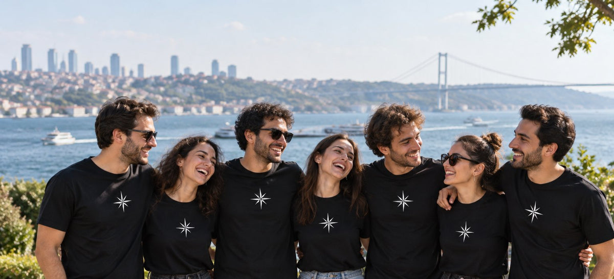 Aynı yıldız baskılı siyah tişörtleri giyen arkadaş grubu, arkada İstanbul Boğazı
